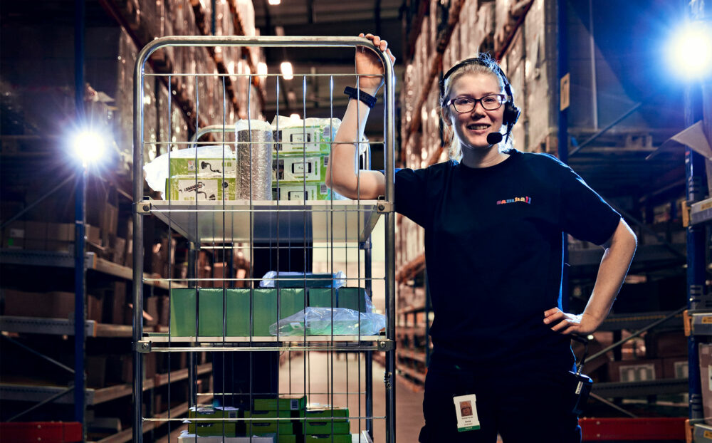 Kvinna håller i en lastvagn. Hon ler mot kameran.