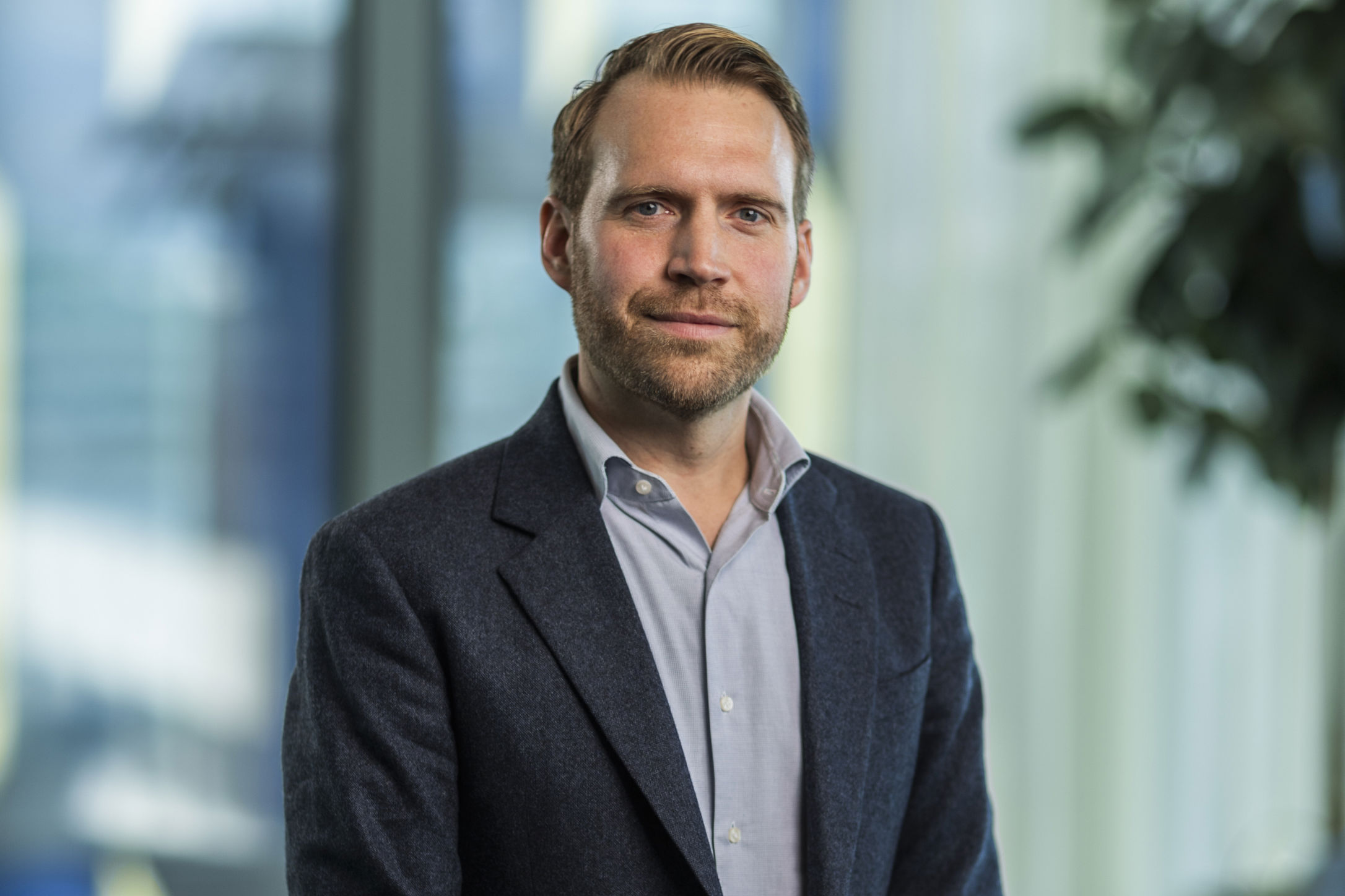 Porträtt på Albin Falkmer. Han bär en mörk kavaj och blå skjorta.