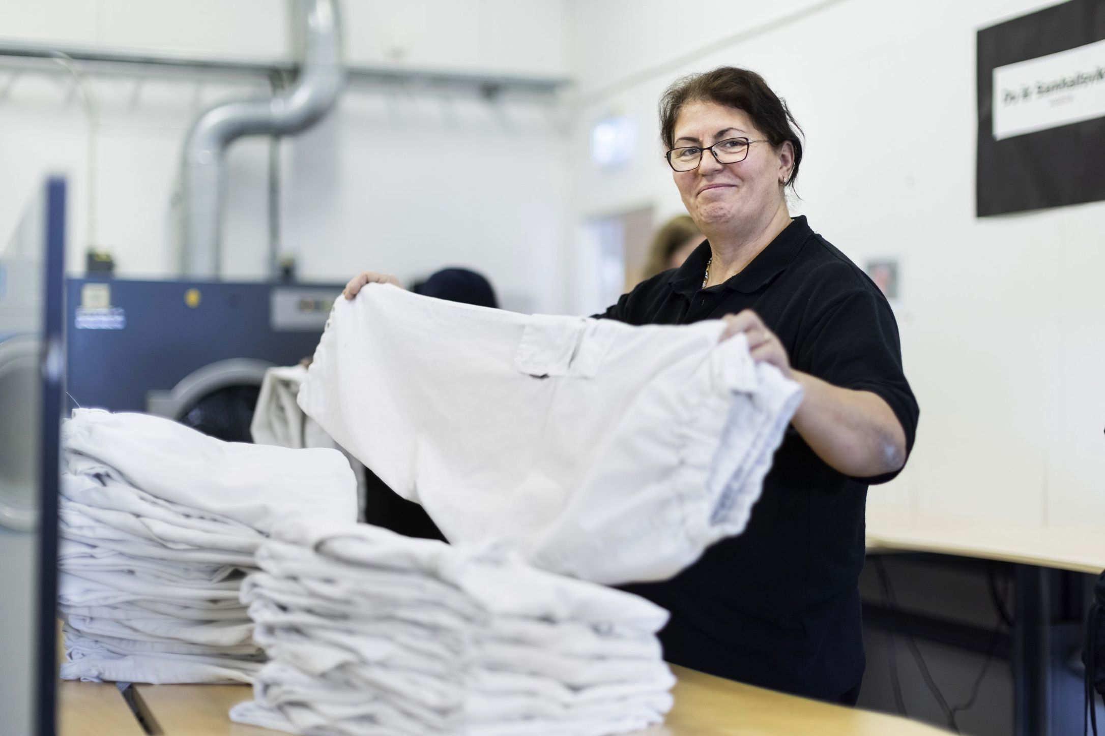 En Samhallmedarbetare arbetar i ett tvätteri