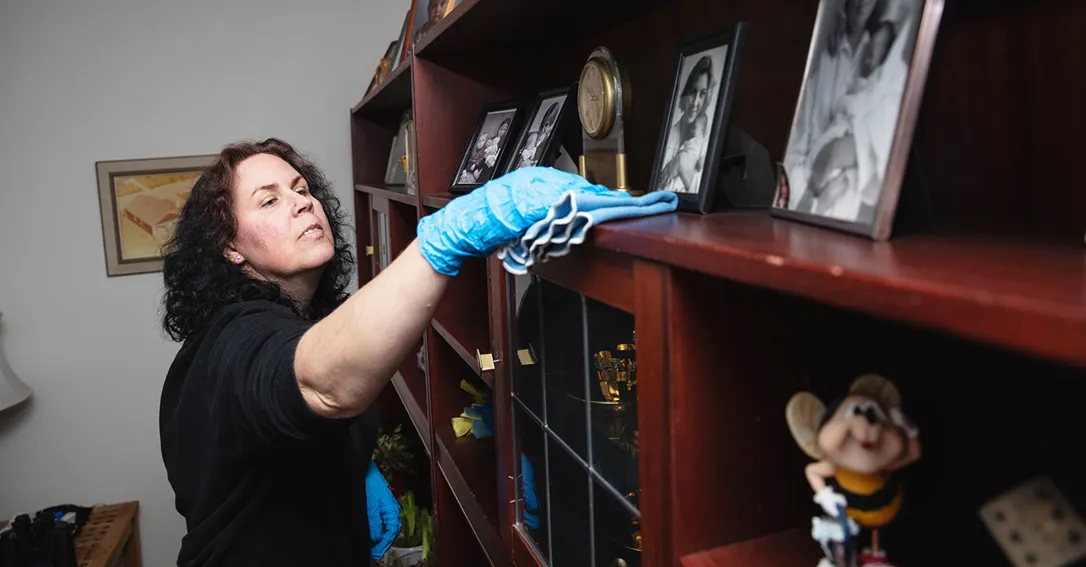 Monica Nilsson på Samhall i Gislaved städar i skåpet hemma hos Mikael Taskinen.