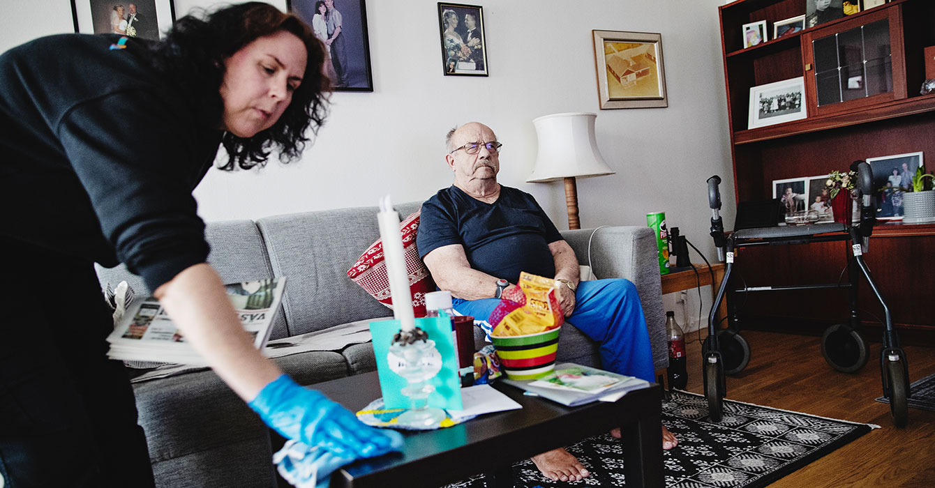 Monika Nilsson torkar med en trasa på vardagsrumsbordet hemma hos Mikael Taskinen.