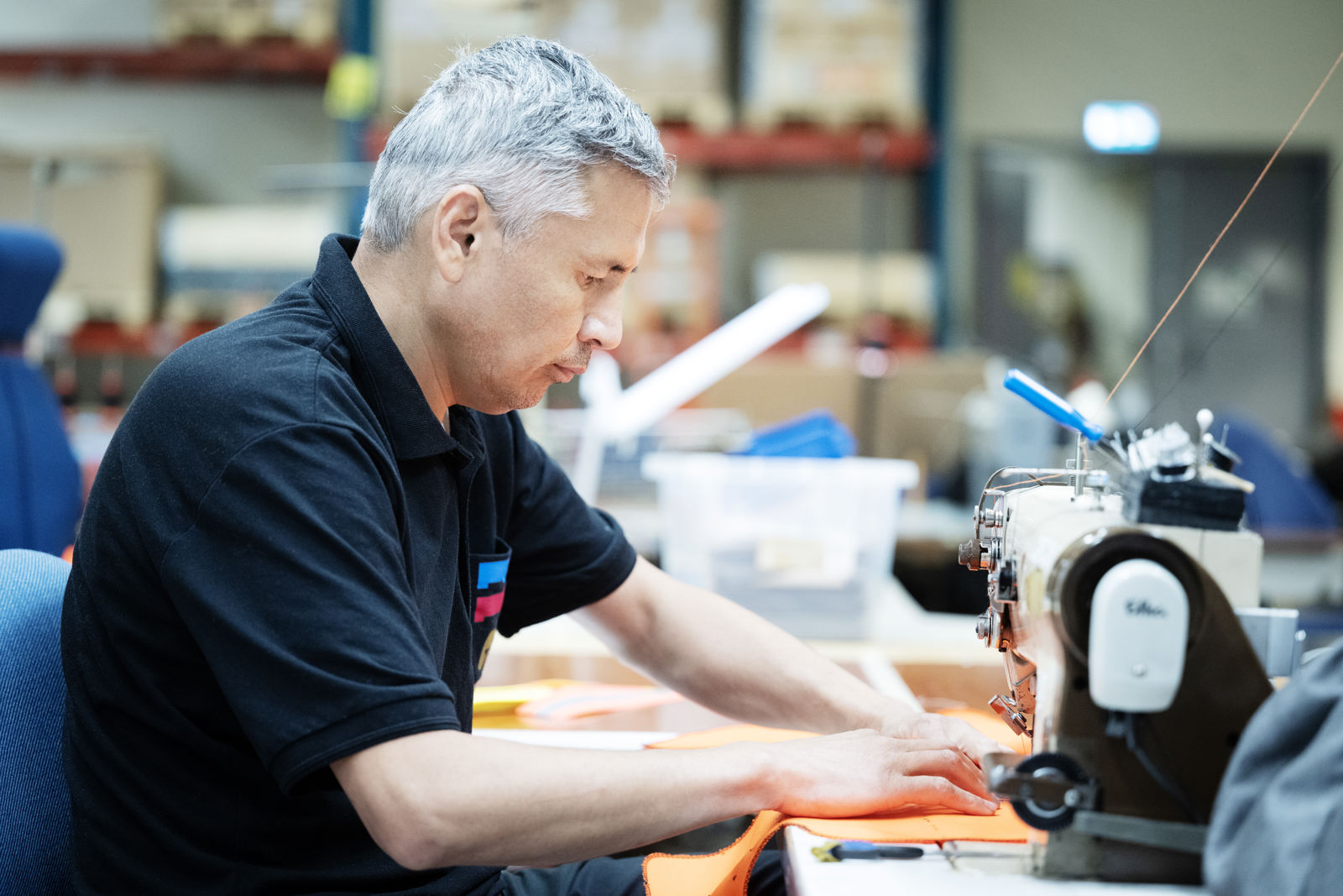 En samhallsanställd arbetar på en symaskin