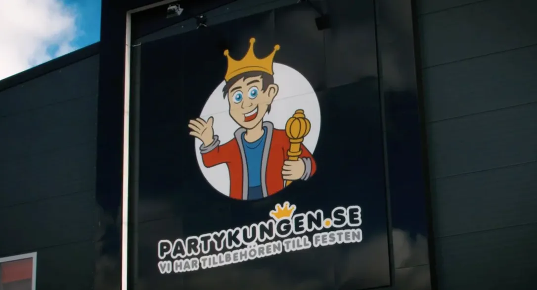 Bild tagen utanför Partykungen, visar deras logo.