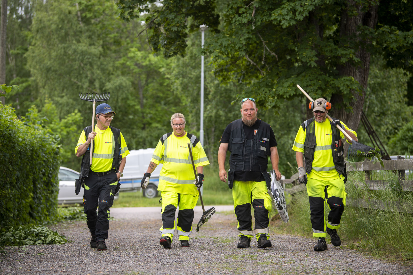 En grupp samhallsanställda som går längs en grusväg.