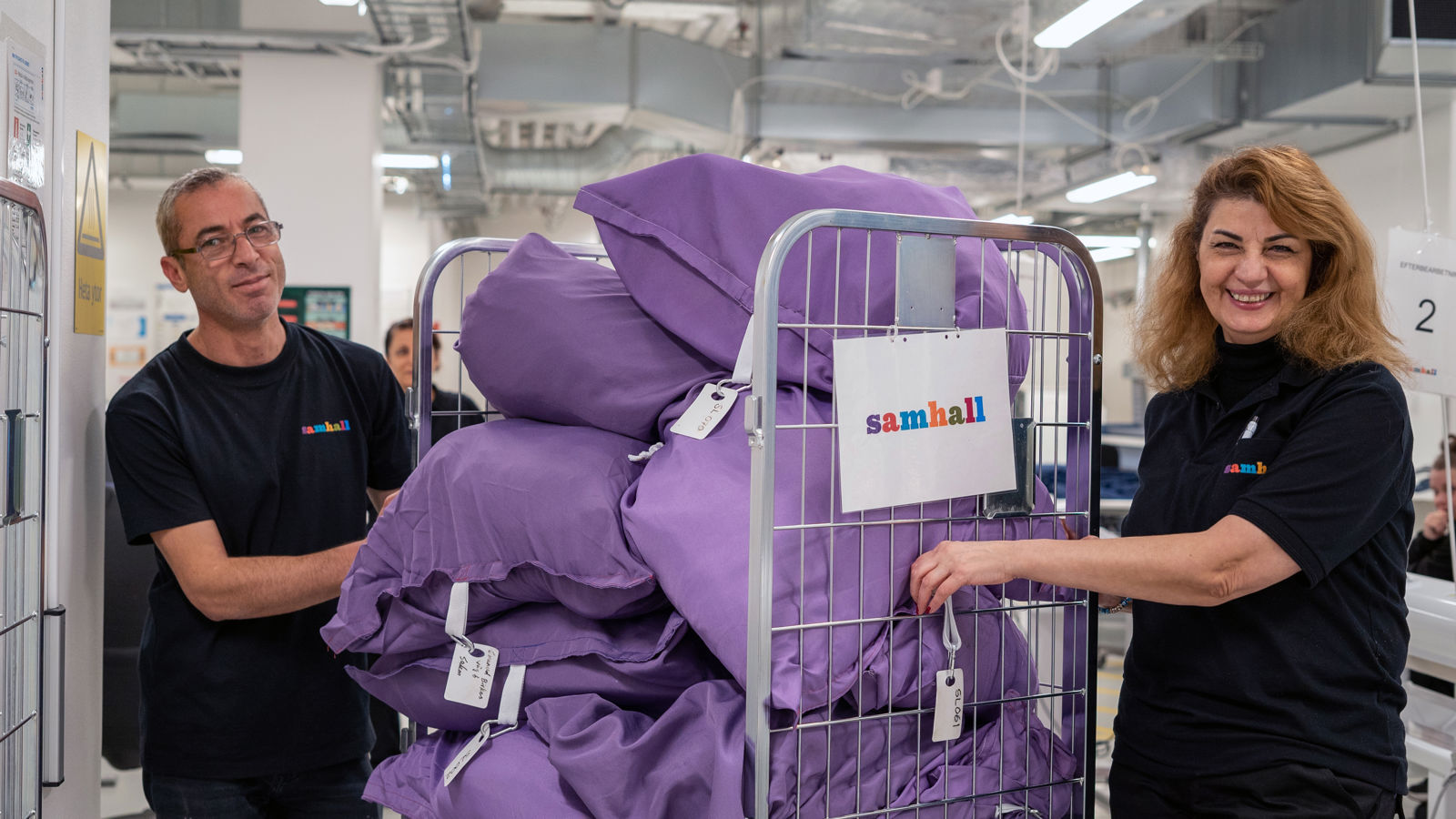 Samhallsmedarbetare hanterar textilier i en tvätterimiljö.