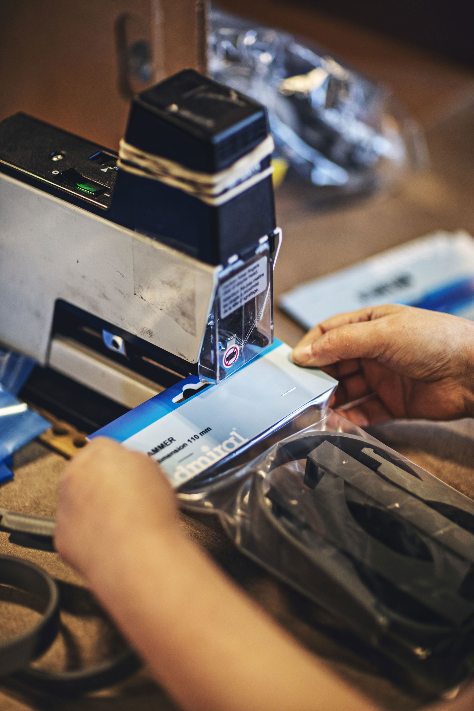 En samhallsanställd häftar fast etikett på produkt.