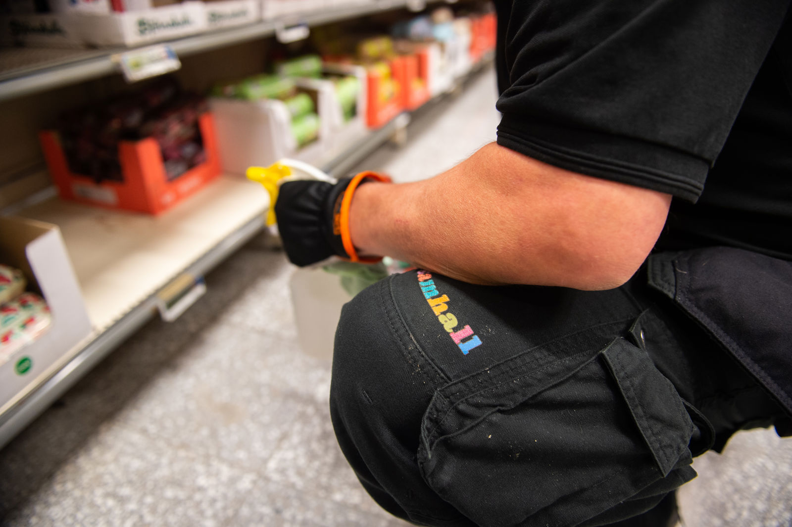 En Samhallsmedarbetare fyller på varor i en butik.