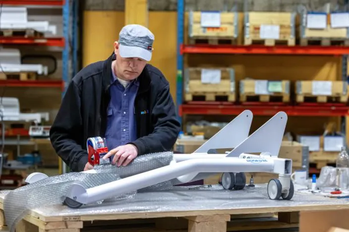 Samhallsmedarbetare arbetar med montering av komponenter till medicinsk utrustning i en produktionsmiljö.