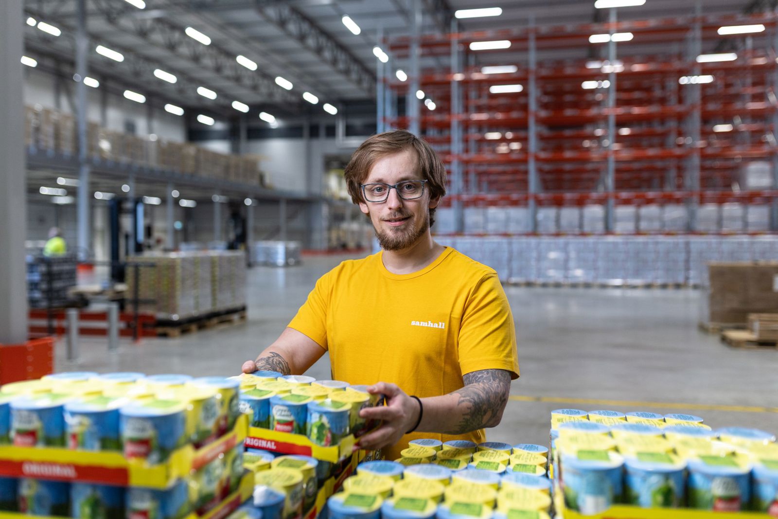 En Samhallsmedarbetare staplar lådor med majs.