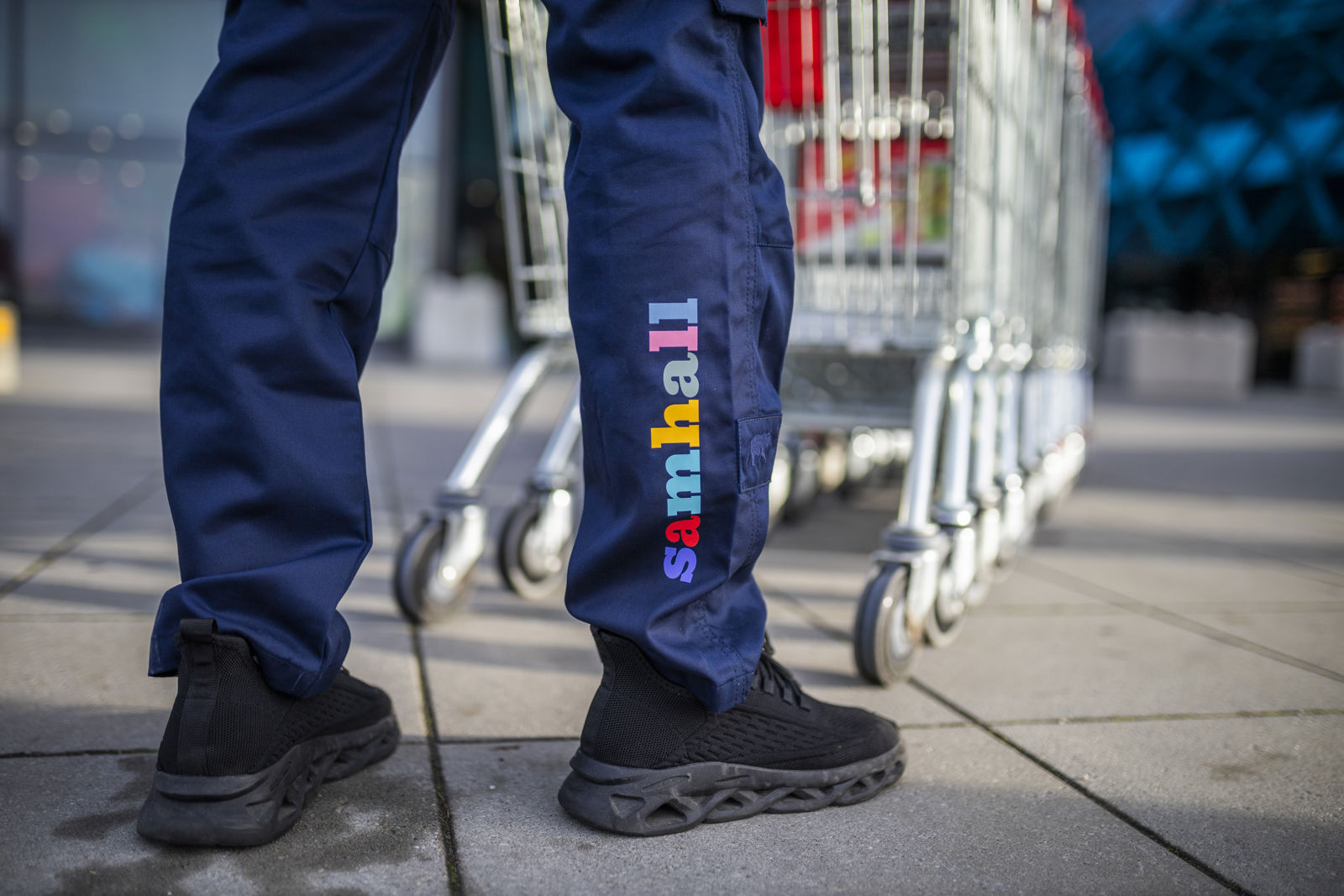 Samhallsmedarbetare står vid kundvagnar utomhus.