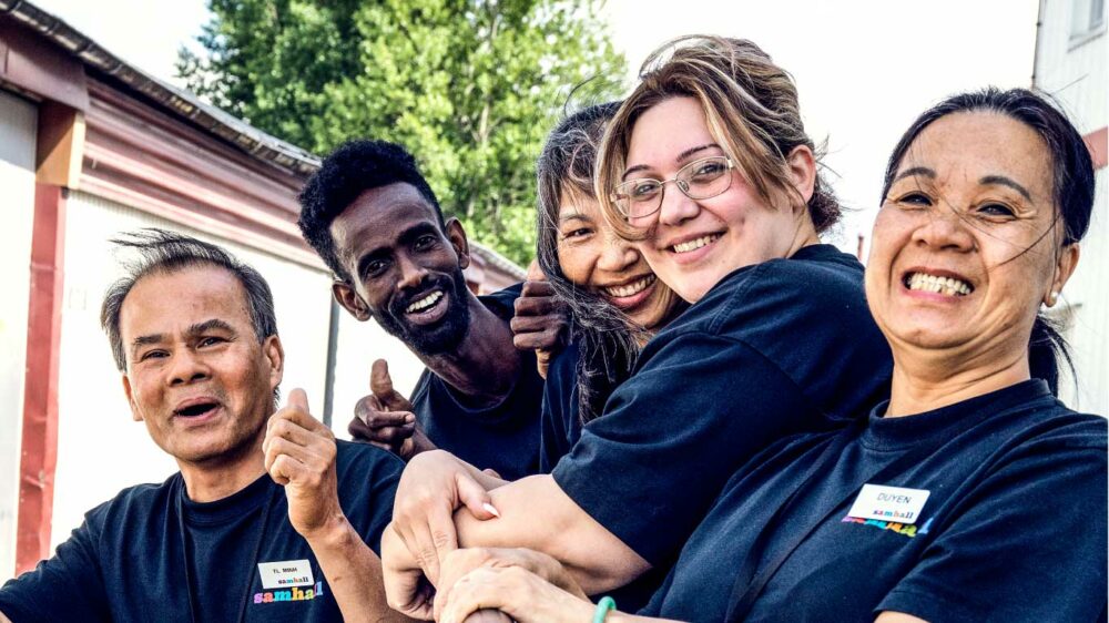 Fem Samhallsanställda ler mot kameran.