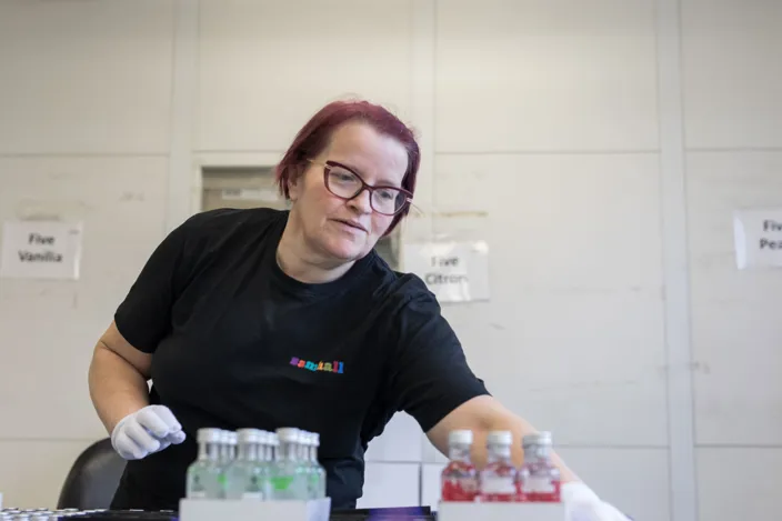 Eva Christoffersson sorterar varor. Hon bär svart klädsel. 