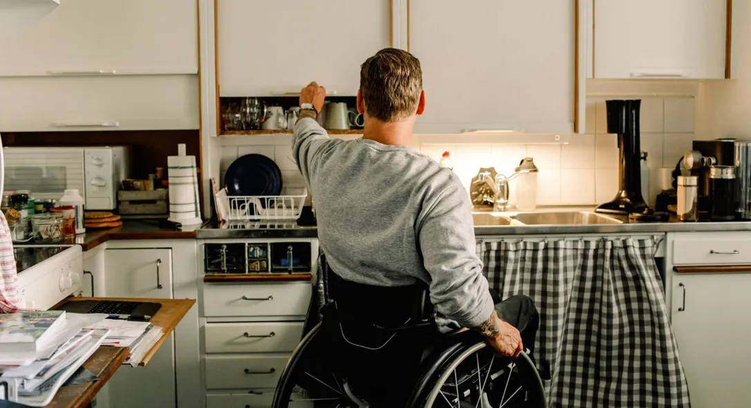 Man i rullstol i ett kök