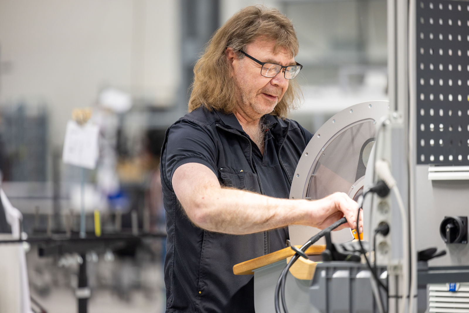 En samhallsanställd som arbetar på en maskin i en fabrik.