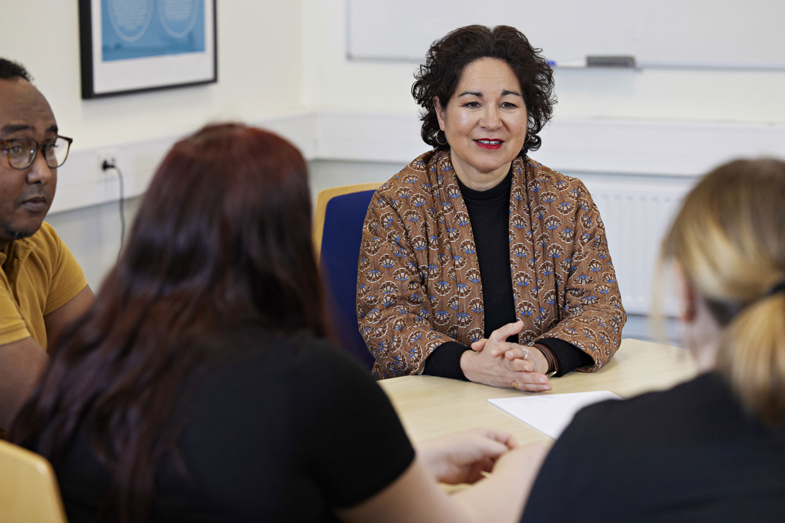 Sabina Rasiwala, HR- och kommunikationsdirektör på Samhall, sitter vid ett bord i samtal med tre personer.