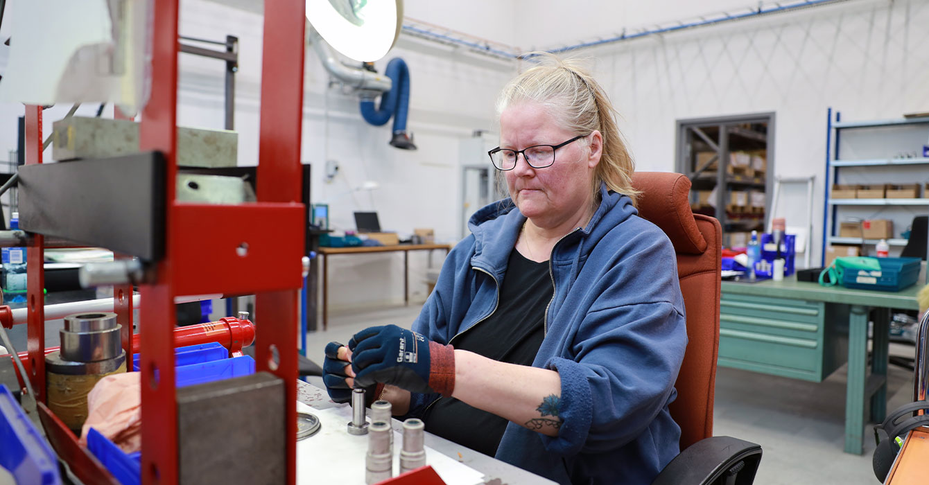 bild på en kvinna som arbetar vid ett arbetsbord i en lagerlokal.