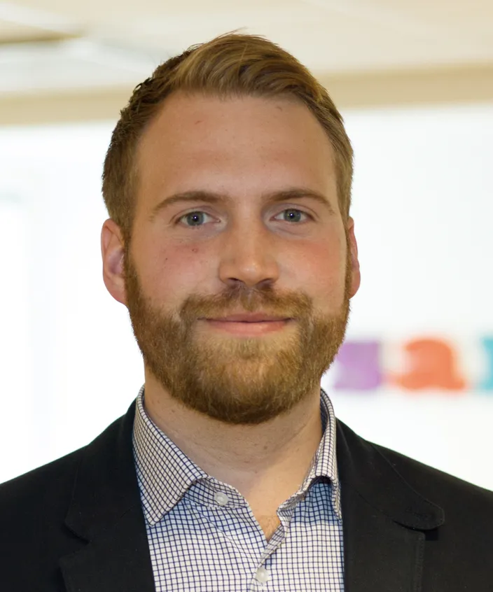 Porträtt av Albin Falkmer. Han har en ljusrutig skjorta och svart kavaj. 