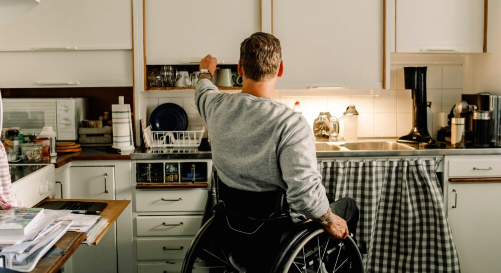 Man i rullstol i ett kök
