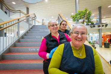Tre kvinnor i Samhall-kläder går efter varandra nedför en trappa