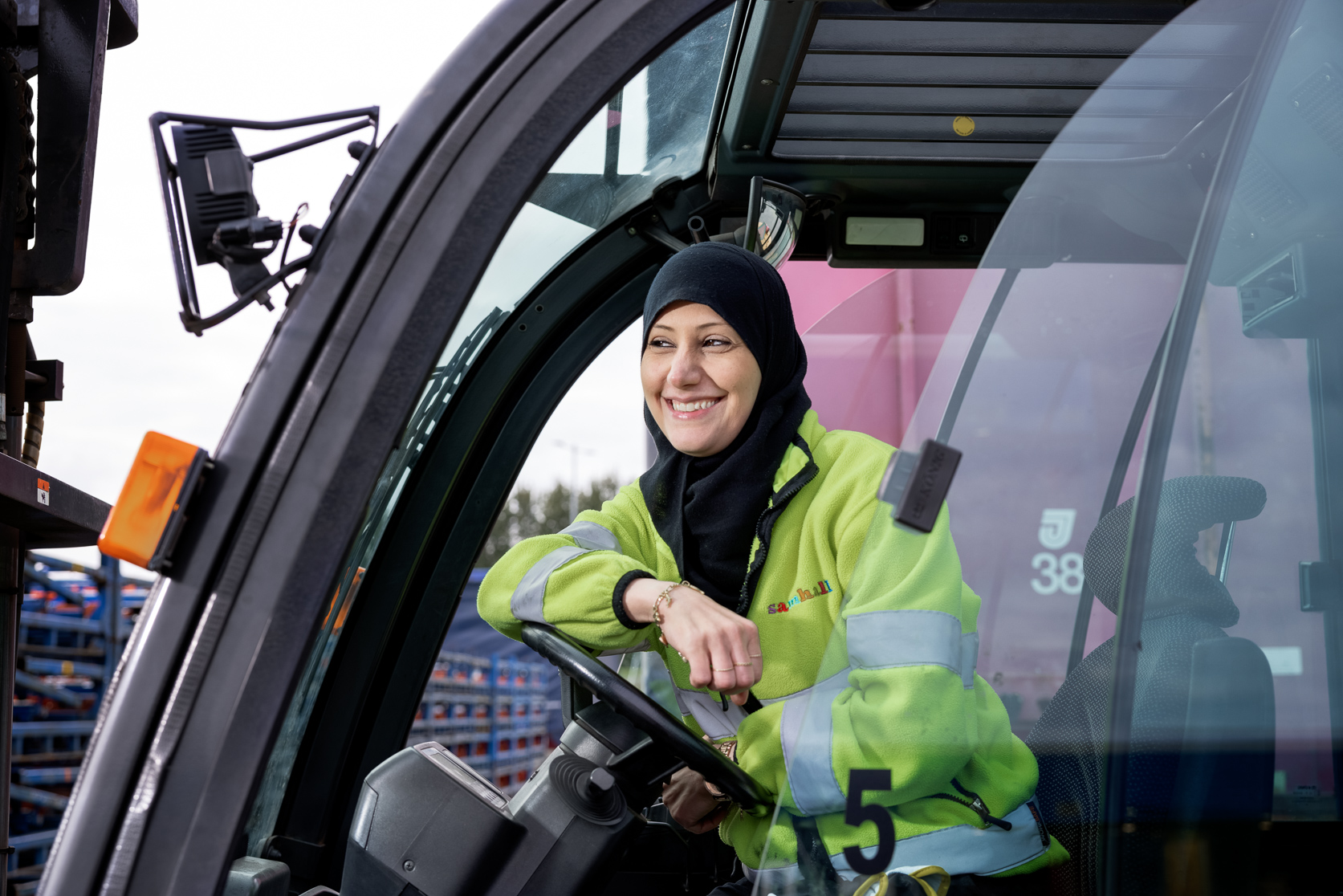 Kvinna i truck ler och lutar sig mot ratten