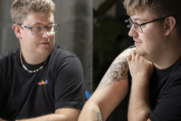 Porträttbild på Pontus visar upp sin tatuering på högerarmen. Linus tittar på den. 