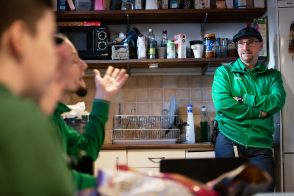 Butikschefen Tony Olaussen samtalar med Stefan Vivallius och Nora Mångsén på lunchrasten. Alla bär gröna uniformer. 