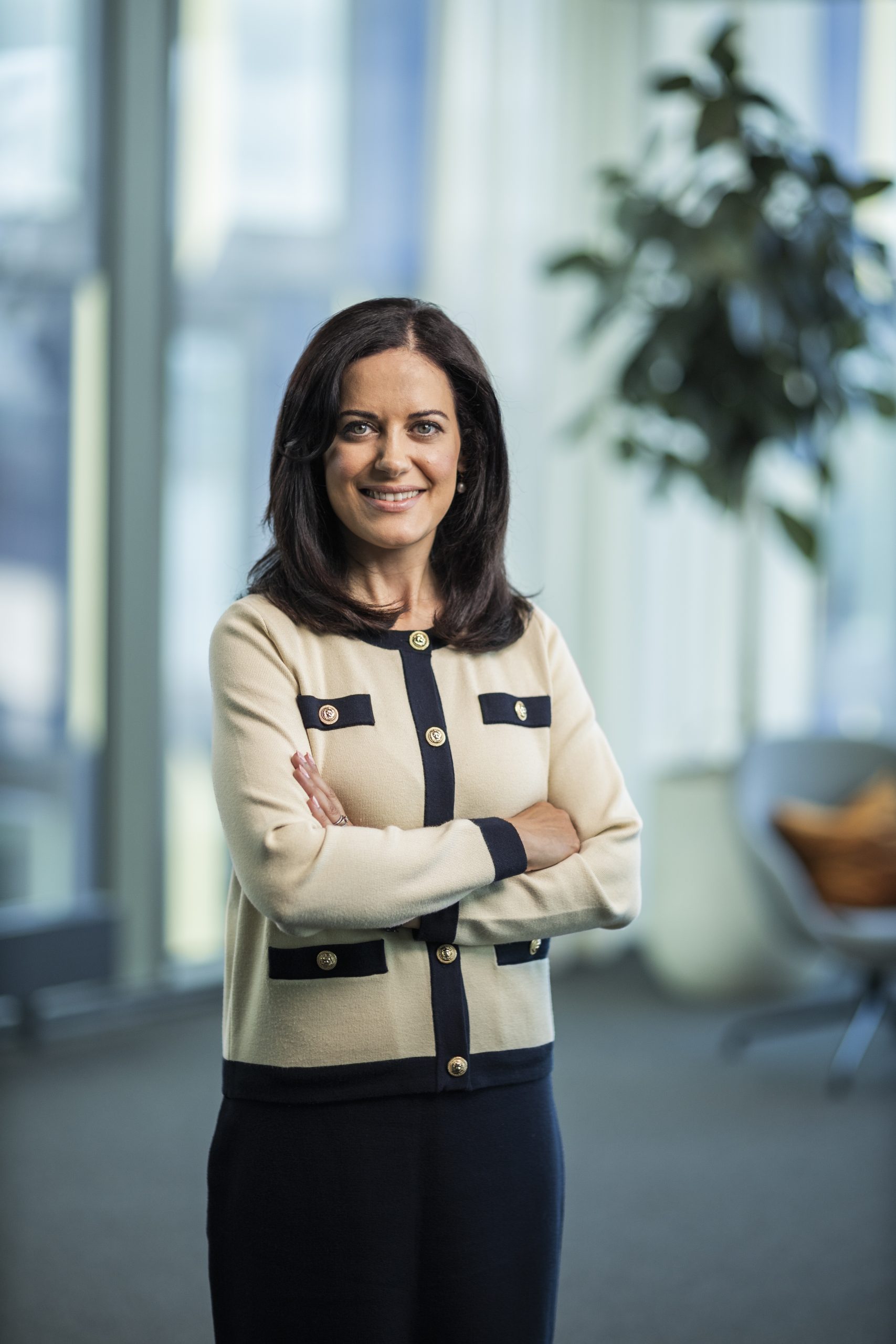 Sara Darabi med mörkt hår och vit kavaj med armarna i kors